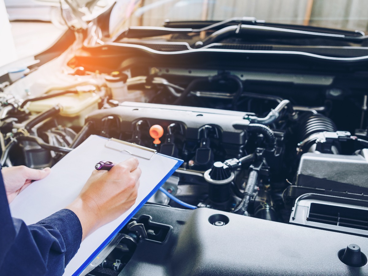 Mechanic holding a clipboard of service order working in garage repair service jpg